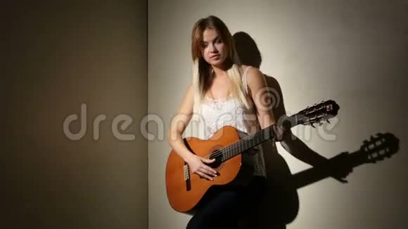 可爱的女孩用明亮的吉他弹奏视频的预览图