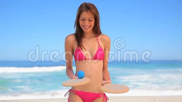 快乐的黑发女人拿着沙滩桨视频的预览图