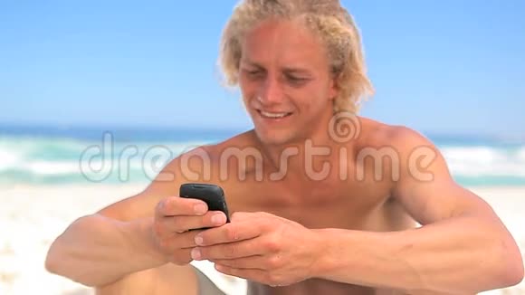 微笑的金发男人用他的手机视频的预览图