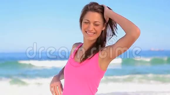 快乐的女人把手放在沙滩上的臀部视频的预览图
