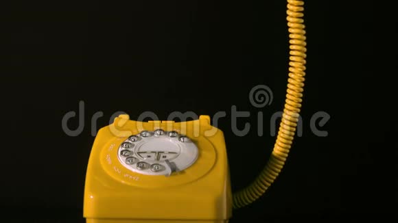 黑色背景下黄色拨号电话上的接收器视频的预览图