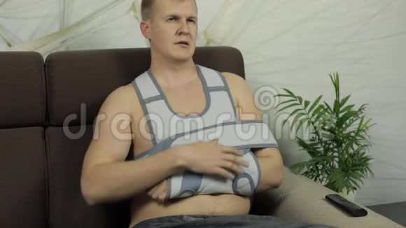 一个痛苦而无聊的男人胳膊断了手臂撑着坐在沙发上视频的预览图