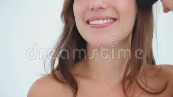 微笑的女人脸上涂着粉底视频的预览图