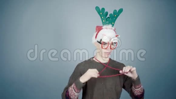 穿着针织毛衣和圣诞帽的年轻人穿上狂欢节服装细节圣诞准备视频的预览图