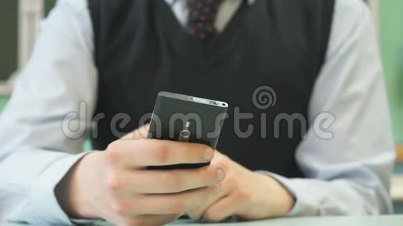 不知名的小学生拿着黑色智能手机视频的预览图
