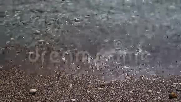 背景透明的海浪在美丽的鹅卵石海滩上流过视频的预览图