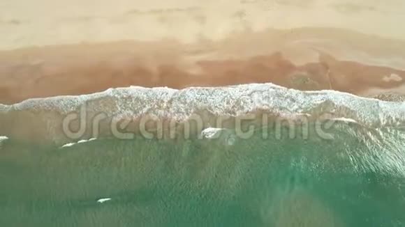 热带白沙滩上波浪的俯视图空中无人机在美丽的海滩上看到4k的海浪视频的预览图