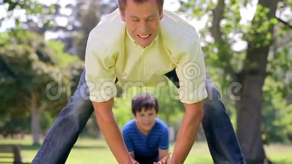 微笑的男人和他的儿子玩橄榄球视频的预览图