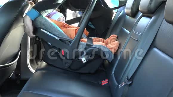 女士系婴儿安全椅带在汽车后座4K视频的预览图