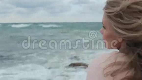 穿着粉色外套在海边的快乐女孩视频的预览图