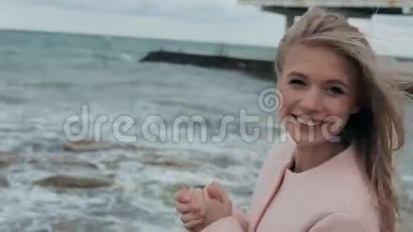 穿着粉色外套在海边的快乐女孩视频的预览图