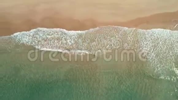 热带白沙滩上波浪的俯视图空中无人机在美丽的海滩上看到4k的海浪视频的预览图