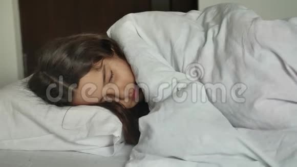 睡在床上的小可爱女孩睡在床上的小女孩黑黑肤色的在室内的生活方式视频的预览图