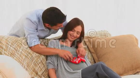 一对玩婴儿鞋的夫妇视频的预览图