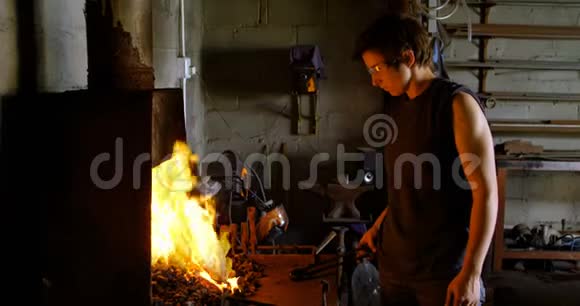 女金属匠用火加热马蹄铁视频的预览图