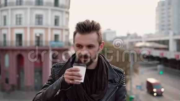 一个有胡子的时髦帅哥一边喝外卖咖啡或茶视频的预览图