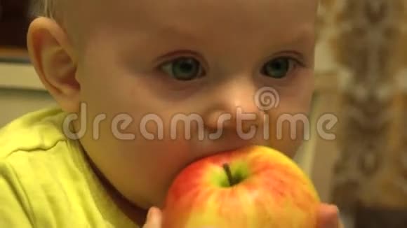 可爱的婴儿吃苹果第一个牙齿先试着咀嚼4K超高清超高清视频的预览图