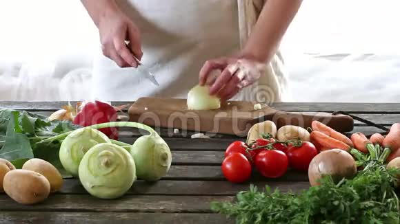 女人切蔬菜女人在木桌上切洋葱视频的预览图