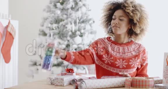 漂亮的年轻女人包装圣诞礼物视频的预览图