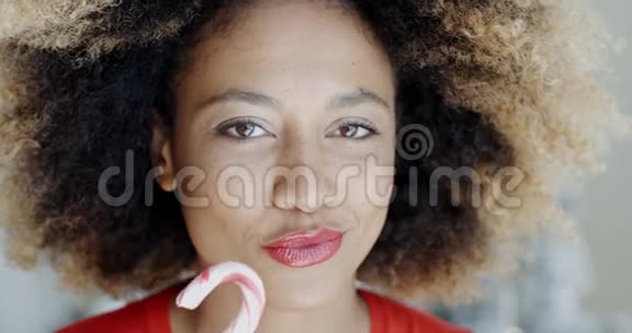 年轻女子咬着节日的甘蔗视频的预览图