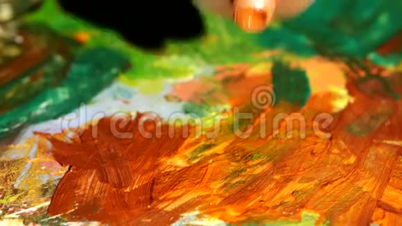 油漆工在调色板上挤压橙色油漆视频的预览图
