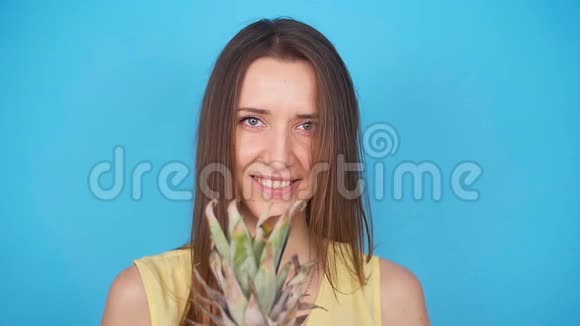 快乐的年轻女人拿着菠萝视频的预览图