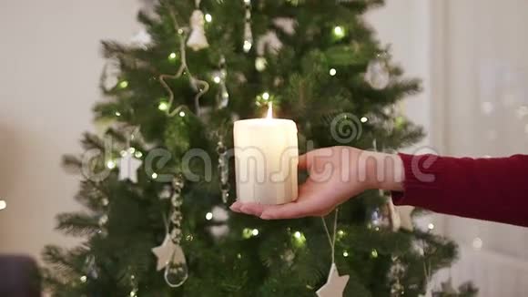 圣诞树前手中的蜡烛视频的预览图