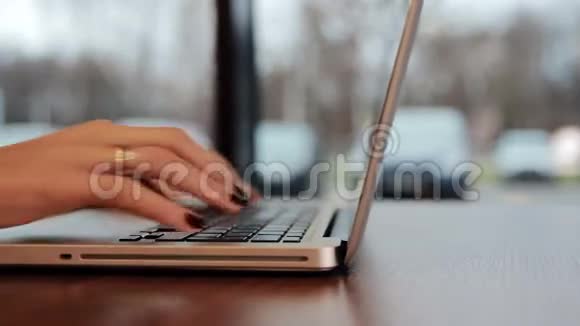 女手在咖啡馆的笔记本电脑上工作左滑滑梯视频的预览图