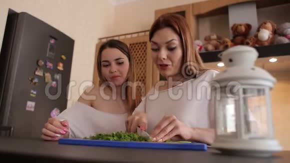两个女孩在厨房准备蔬菜沙拉视频的预览图