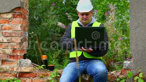室外配备个人电脑和茶帽的建筑工程师视频的预览图
