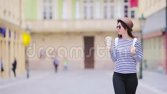 欧洲城市快乐的年轻都市女性白人游客沿着欧洲荒芜的街道散步温暖的夏天视频的预览图