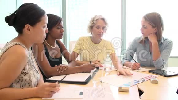 办公室办公桌旁的女企业家小组会议视频的预览图