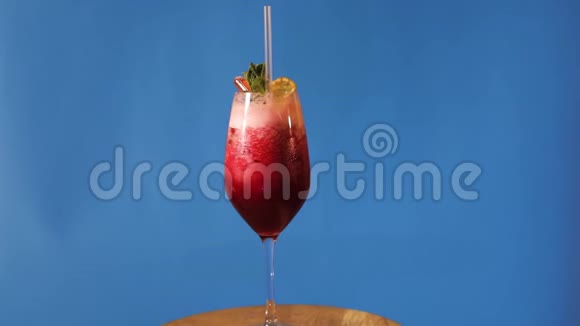 蓝色背景的红色鸡尾酒蓝色背景的鸡尾酒蓝色背景的酒精鸡尾酒视频的预览图