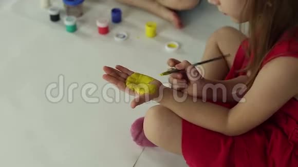 孩子们用画笔手掌和水粉画纸视频的预览图