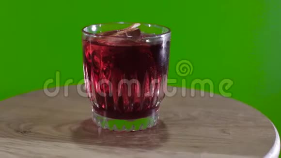 绿色背景上的威士忌酒杯hromokoy背景上的鸡尾酒旋转绿色背景上的酒精鸡尾酒视频的预览图