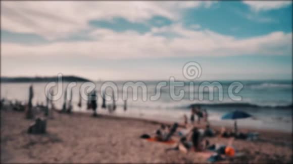 大西洋海岸坎塔布里亚海许多日光浴的人五颜六色的雨伞温暖的景色视频的预览图
