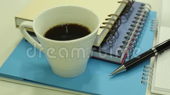 带优雅笔的笔记本和一杯热咖啡视频的预览图