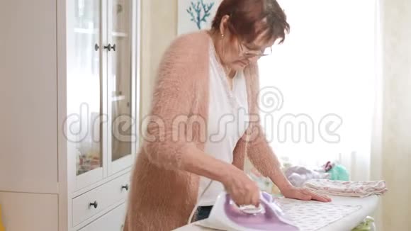 老妇人在家熨衣服视频的预览图