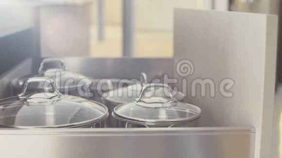 豪华厨房里一个装有不锈钢壶的抽屉的跟踪镜头视频的预览图