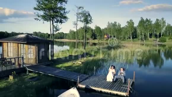 年轻的新婚夫妇在码头享受夏日视频的预览图