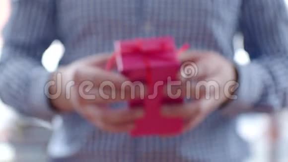 带红丝带的粉色盒子里送礼物的男人视频的预览图