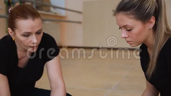 两个穿着黑色衣服的舞者想出了一个新的舞蹈在地板上视频的预览图