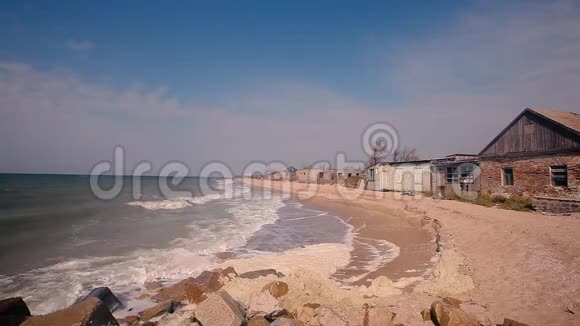 海岸上的建筑被毁海边的秋意沙滩上的波浪翻滚视频的预览图