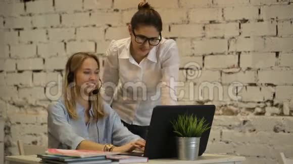 两个年轻的女商人在电脑上工作并在电脑上抽烟视频的预览图