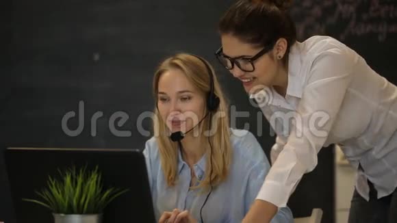 两个年轻的女商人在电脑上工作并在电脑上抽烟视频的预览图