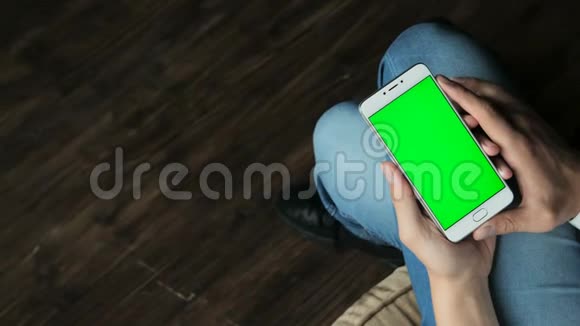 男人手拿智能手机绿色屏幕显示视频的预览图