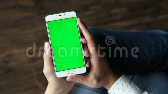 男人手拿智能手机绿色屏幕显示视频的预览图
