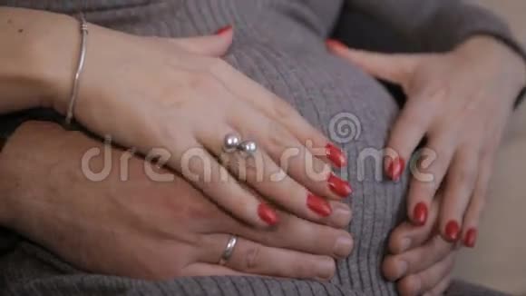 男性和女性的手抚摸怀孕的腹部视频的预览图