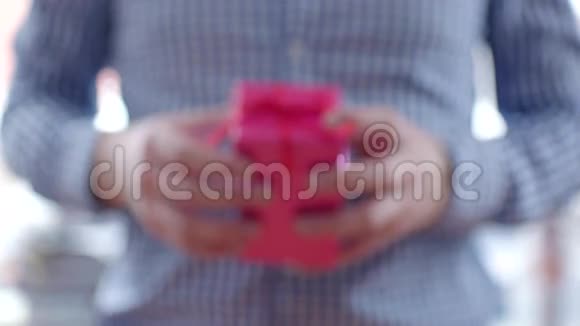 带红丝带的粉色盒子里送礼物的男人视频的预览图