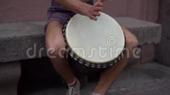 一个街头音乐家演奏鼓市中心有魅力的嬉皮士鼓手演奏非洲图案视频的预览图